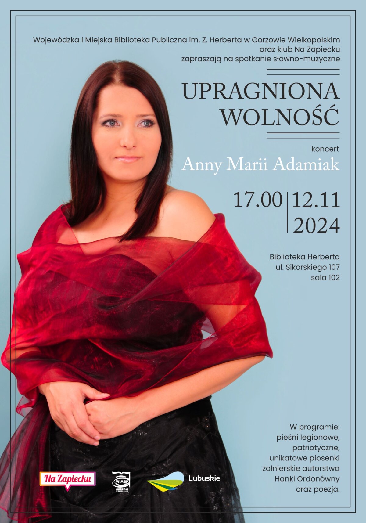 Plakat spotkania słowno-muzycznego pod hasłem "Upragniona Wolność". W tle fotografia Anny Marii Adamiak, której koncert będzie stanowił główną część wydarzenia. Kobieta przedstawiona na zdjęciu jest w czarnej sukience i czerwonym szalu, elegancko prezentująca się na jednokolorowym, błękitnym tle. Całość wieńczy delikatna, czarna, podwójna ramka podkreślająca elegancki charakter spotkania.