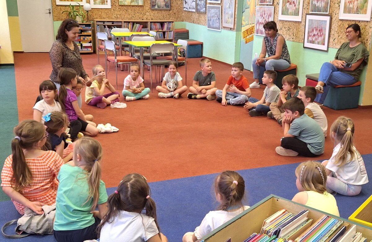 1. Dzieci siedzą w kółku na dywanie. Bibliotekarka prowadzi pogadankę na temat zasad panujących w bibliotece.