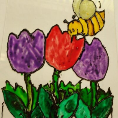 Praca plastyczna przedstawiająca namalowane na szkle trzy tulipany w kolorach fioletowym i czerwonym oraz siedzącą na nich pszczołę. Kliknięcie w obrazek spowoduje powiększenie.