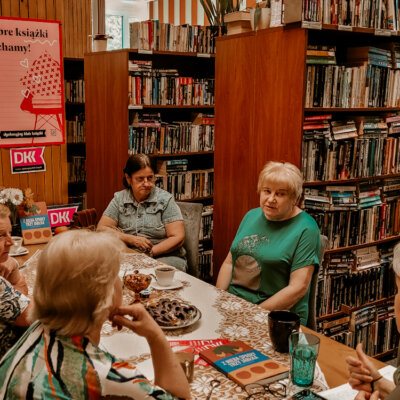 Wnętrze Filli nr 8. Trwa Dyskusyjny Klub Książki. Sześć kobiet siedzi przy stole i rozmawia o omawianej książce. Jedna z kobiet coś mówi, inne jej słuchają. Toczy się dyskusja. Kliknięcie powoduje powiększenie zdjęcia.