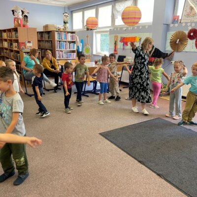 Dzieci z panią prowadzącą tańczą z pokazywaniem w rytm piosenki. Kliknięcie powoduje powiększenie zdjęcia.