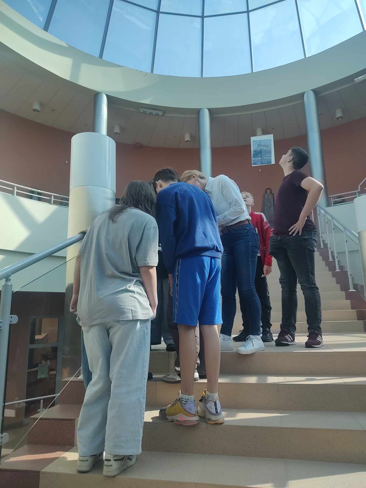 grupa rozwiązuje zadania na schodach