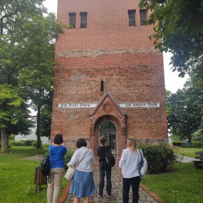 Czwórka uczestników przed ruinami kościoła w Podelzig