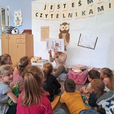 Bibliotekarka czyta książkę i pokazuje ilustracje. Kliknięcie w obrazek spowoduje powiększenie.