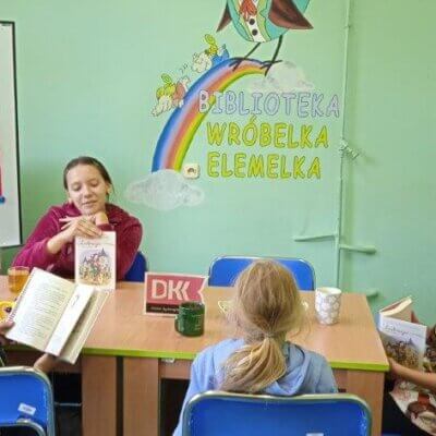 Prezentacja książki Lukrecja poza zasięgiem - prezentuje dziewczynka siedząca przy stole.