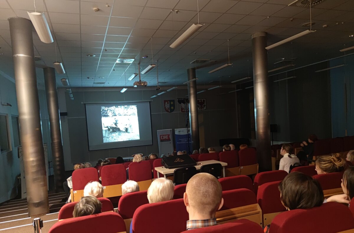 Na zdjęciu widoczna aula WiMBP, uczestnicy spotkania siedząc na widowni, oglądają film dokumentalny o Simonie Kossak.