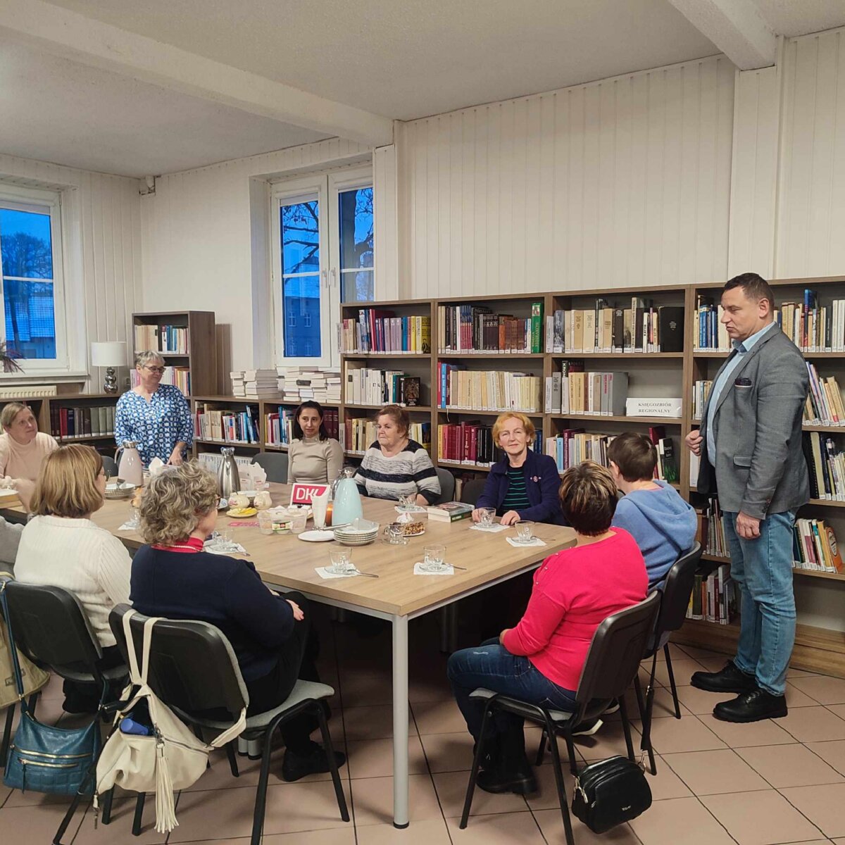 Na zdjęciu znajdują się uczestnicy spotkania DKK. Wszyscy rozmawiają na temat wybranej książki.