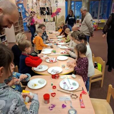 Na fotografii młodzi uczestnicy wykonują z gliny różne przedmioty. Kliknięcie powoduje powiększenie zdjęcia.