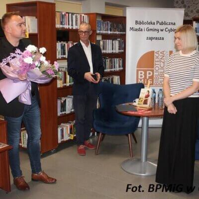 Burmistrz wręcza autorce bukiet kwiatów w pomieszczeniu biblioteki. Kliknięcie powoduje powiększenie zdjęcia.