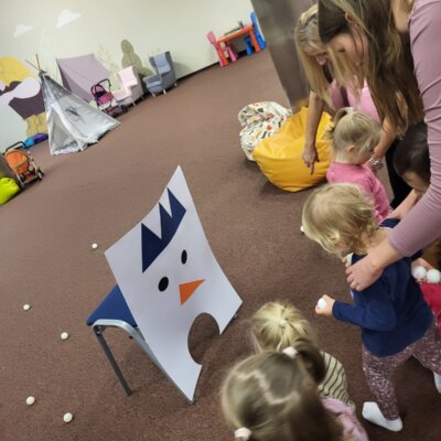 Podopieczni karmią bałwanka kulami śniegu. Kliknięcie powoduje powiększenie zdjęcia.