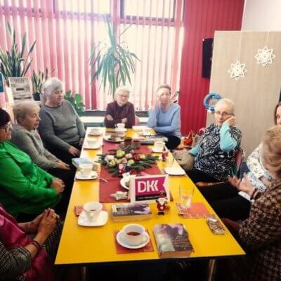 grupa kobiet siedzi przy stole i rozmawiają. Na spotkaniu towarzyszy uczestnikom pogodna atmosfera. Kliknięcie w obrazek spowoduje powiększenie.